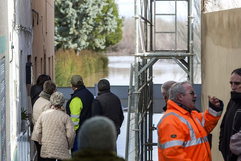 Vecinos de Novillas, en Zaragoza, observan la crecida del Ebro