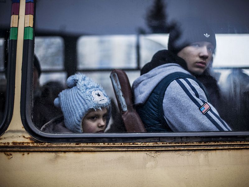 Un niño y un adolescente dicen adiós a su ciudad, en ruinas por la guerra.