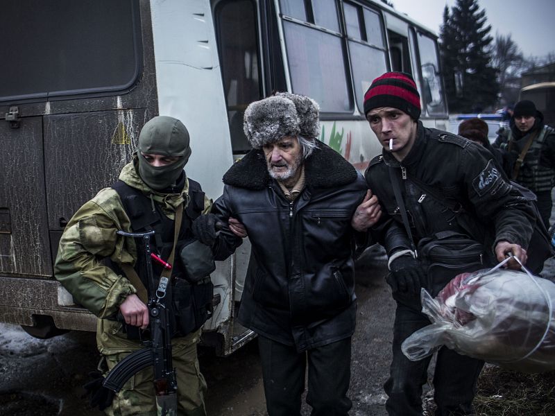 Un anciano es ayudado por miembros del Ejército ucraniano a abandonar su casa. AFP PHOTO / MANU BRABO