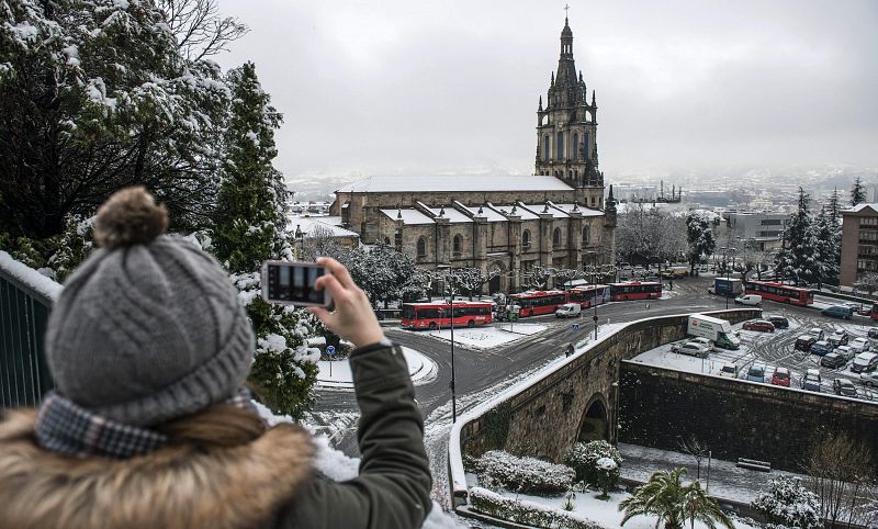 Una mujer toma una fotografía de la Basílica de Begoña en Bilbao (Vizcaya).