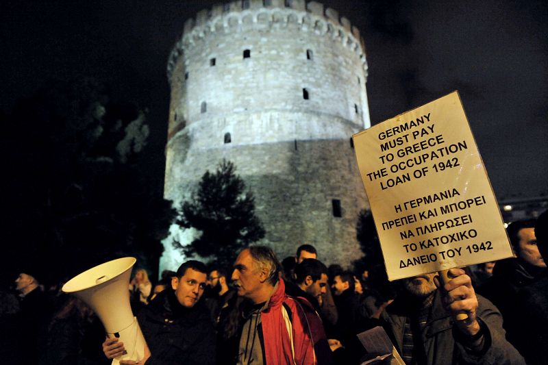 Un manifestante en la ciudad griega de Tesalónica reclama a Alemania en una pancarta los costes de la ocupación del país durante la Segunda Guerra Mundial