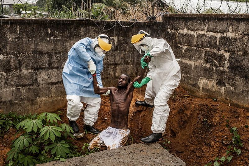 Personal sanitario de un centro de atención a enfermos de ébola ayuda a un enfermo en estado de delirio tras escaparse de la sala de aislamiento del centro en Hastings (Sierra Leona), el pasado 23 de noviembre de 2014.