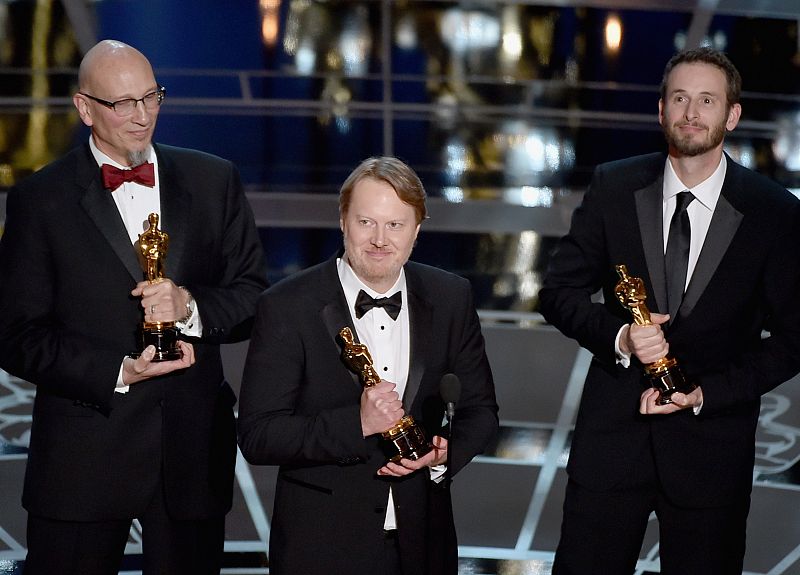 El director Don Hall recoge el oscar a la mejor cinta de animación por 'Big Hero 6', junto a él, Chris Williams y Roy Conli