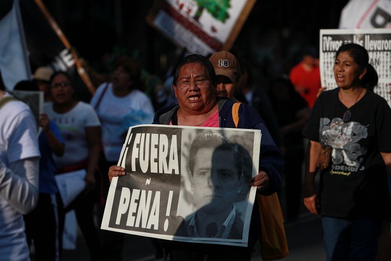 Una mujer mexicana sostiene un cartel contra el presidente mexicano Enrique Peña Nieto