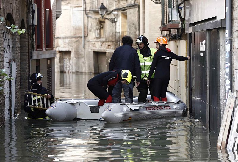 Un bombero accede a un bar del casco viejo de Tudela tras la crecida del Ebro