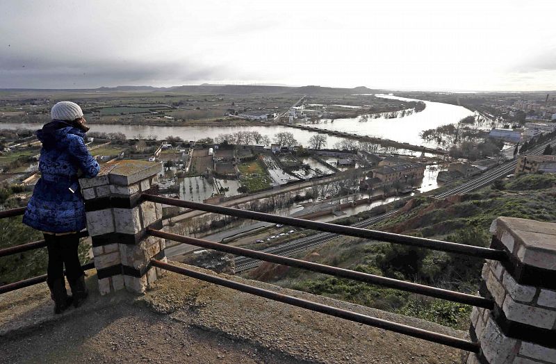 Una mujer observa la crecida del río Ebro, que ha pasado ya por Tudela