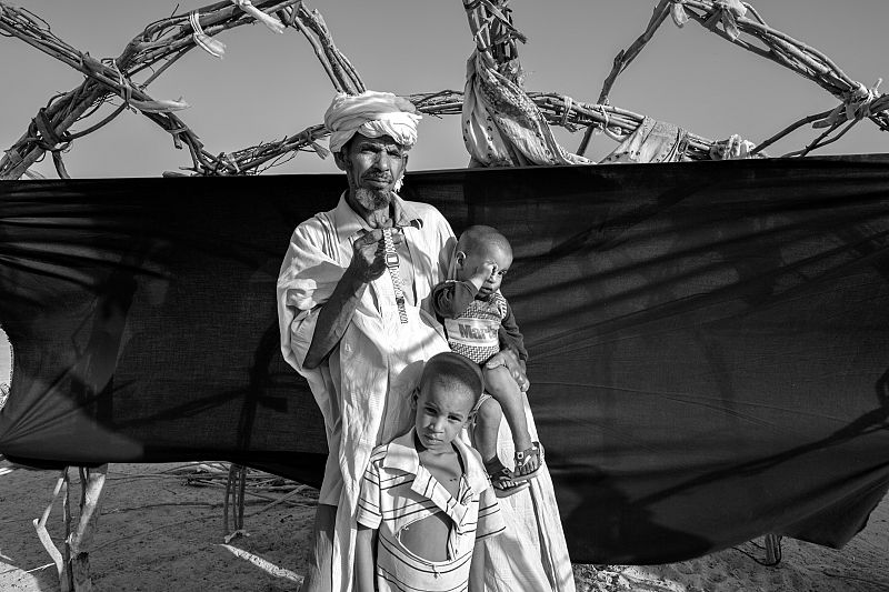 Omar Al-Bashir, con sus hijos, en el campamento de Mentao, sostiene su reloj digital.