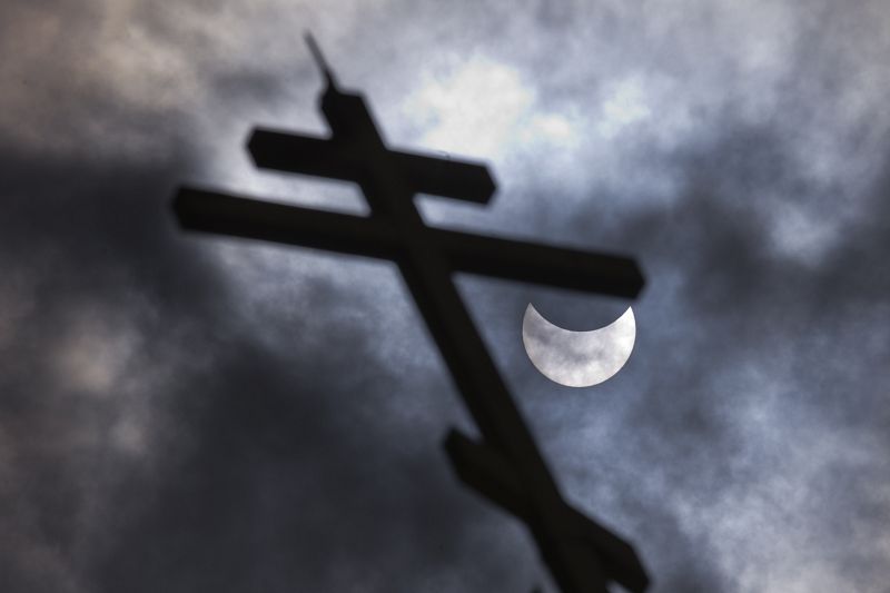 Detalle del disco solar visto tras una cruz de la iglesia de San Nicolás en Sofía, capital de Bulgaria.