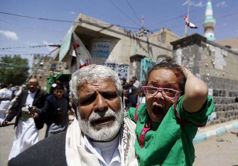 Un hombre huye con una niña en brazos tras una de las explosiones perpetradas por suicidas contra mezquitas chíies en diferentes barrios de Saná, Yemen.