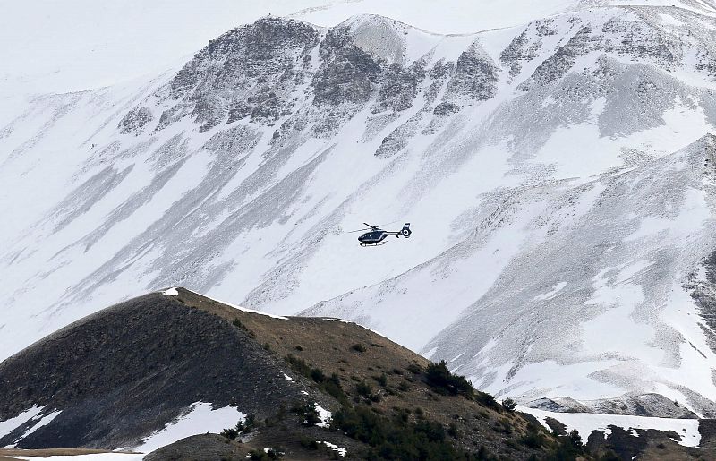 Un helicóptero de rescate francés sobrevuela los montes cubiertos de nieve de los Alpes en el segundo día de búsqueda de restos del vuelo accidentado de Germanwings.