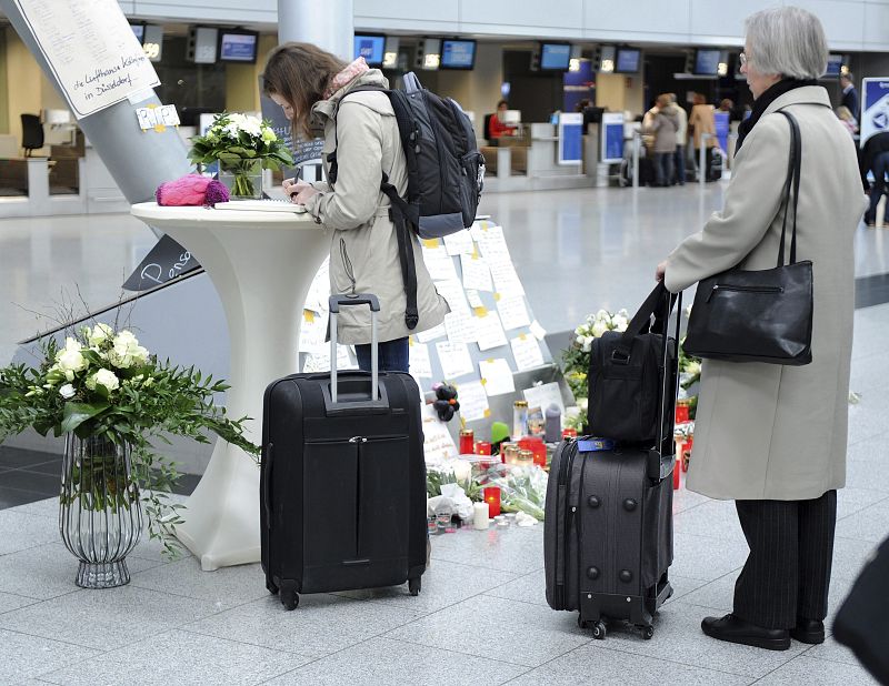 Viajeros firman el libro de condolecias en memoria de las víctimas del vuelo de Germanwings