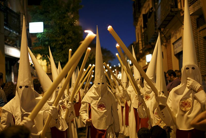Penitents of the Siete Palabras brotherhood make their penance during a Holy Week procession in the Andalusian capital of Seville