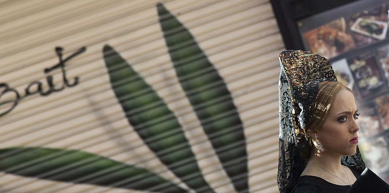 Una joven vestida de mantilla espera para visitar al Cristo del Gran Poder durante el Jueves Santo en Sevilla