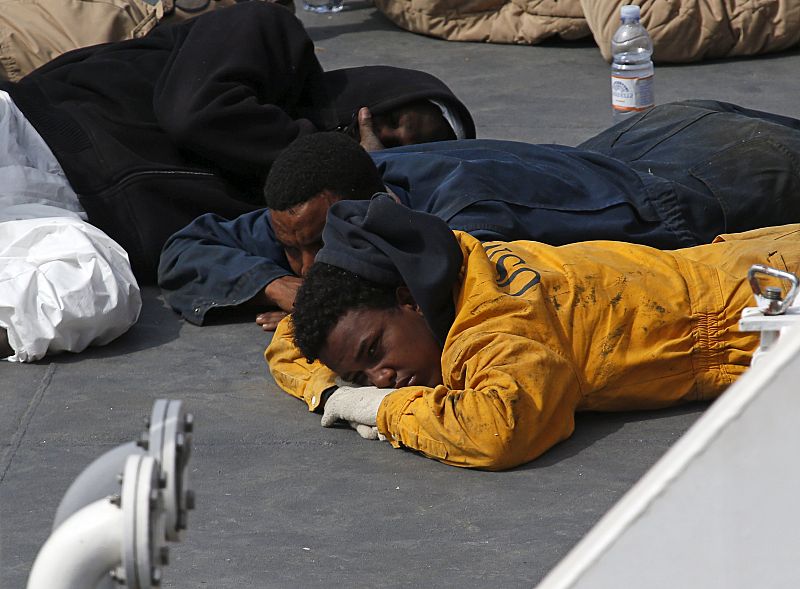 Uno de los supervivientes del naufragio yace tendido en la cubierta del barco 'Gregoretti' de la Guardia Costera italiana