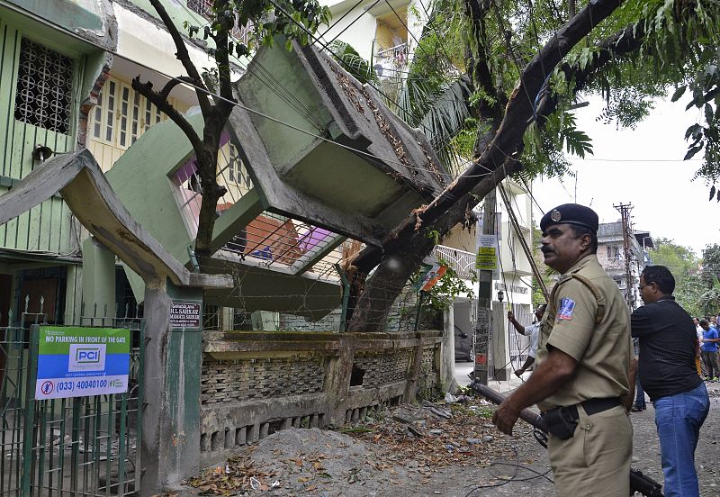 Un personal de seguridad se encuentra cerca de una casa derrumbada después del terremoto que se ha sentido también en Siliguri, India.