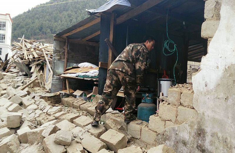 Un colaborador en tareas de rescate, en una casa derruida en Xigaze, Nepal