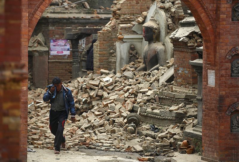 Un hombre llora mientras camina entre los escombros en Bhaktapur