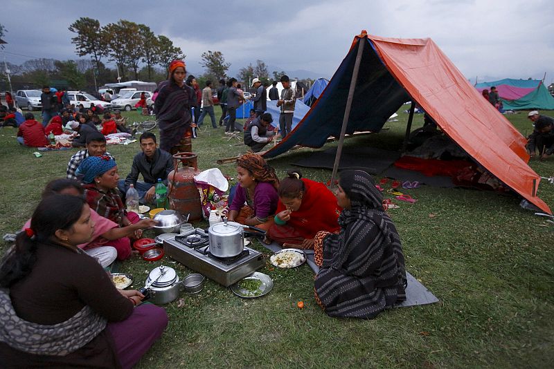 Miembros de una familia cenan frente a un refugio improvisado tras el terremoto en Katmandú, Nepal.