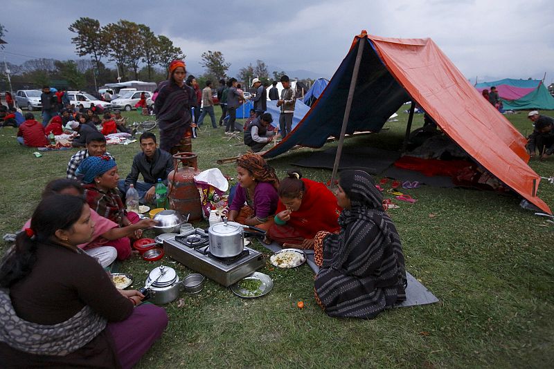 Miembros de una familia cenan frente a un refugio improvisado tras el terremoto en Katmandú, Nepal.