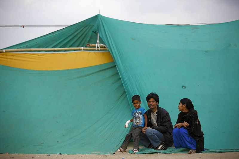 Un niño que resultó herido durante el terremoto de Nepal se sienta junto a su familia en un refugio improvisado en Katmandú.
