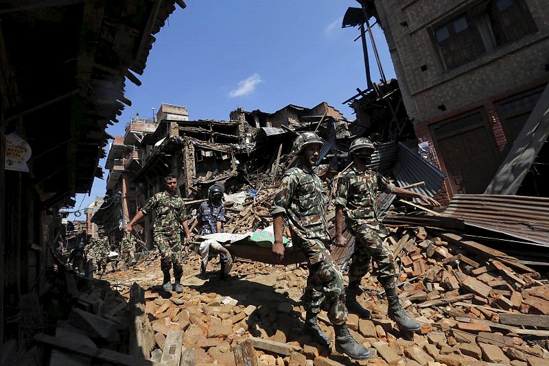 Miembros del Ejército de Nepal llevan un cadáver recuperado de los escombros