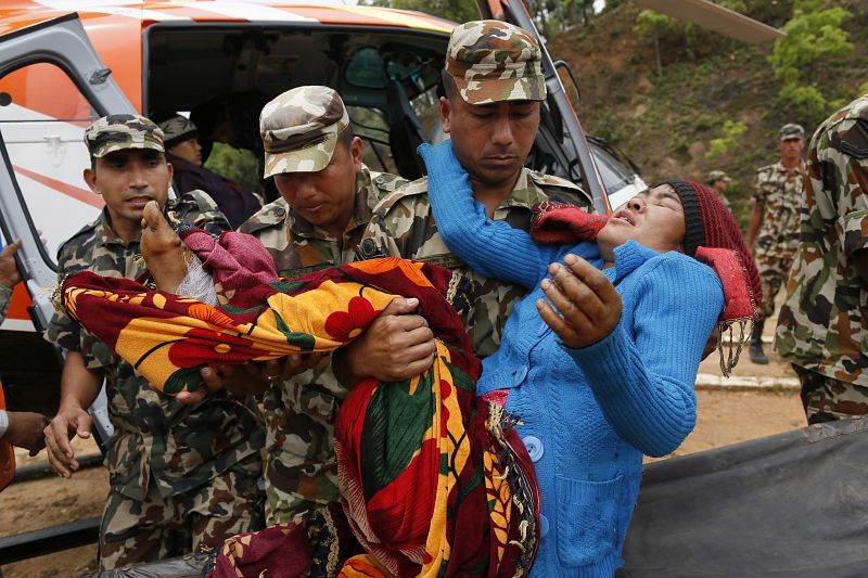 Una superviviente con una pierna rota es evacuada por miitares de la localidad de Ranakur, muy dañada por el seismo