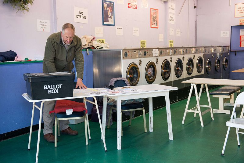 El presidente  de la mesa prepara los papeles para votar en una lavandería en Headington, cerca de Oxford