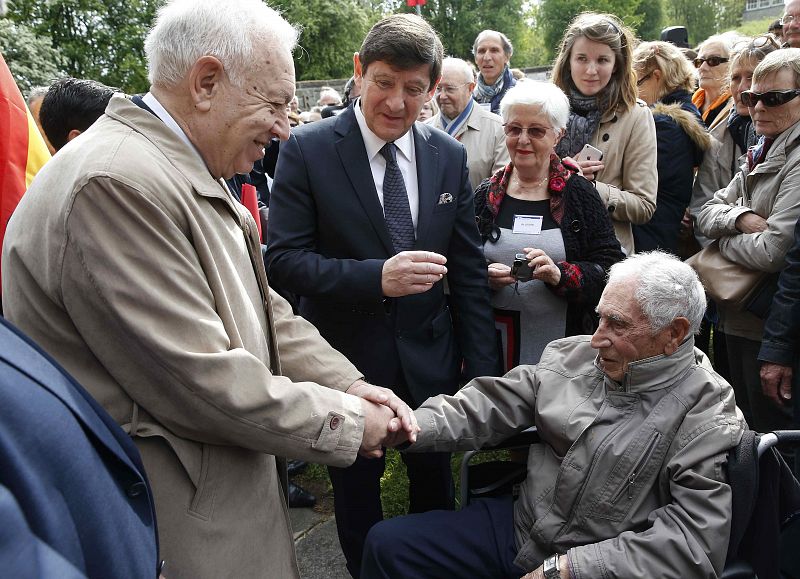 José Manuel García Margallo (i), saluda al republicano español Cristobal Soriano, de 96 años, sobreviviente del campo de exterminio nazi de Mauthausen.