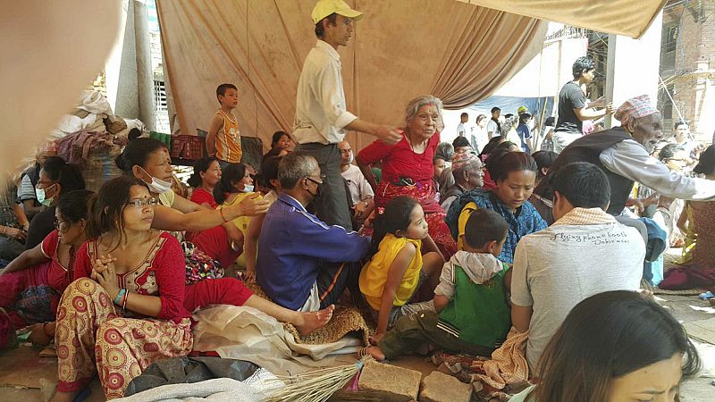 La gente se reúne en un refugio temporal en la ciudad nepalí de Bhaktapur, donde un edificio de cinco plantas que había quedado dañado en el anterior seísmo se ha derrumbado.