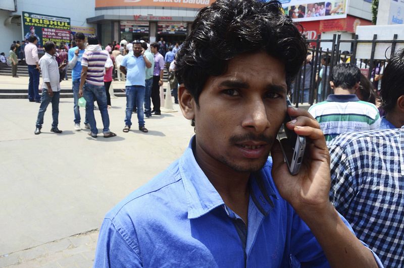 Un hombre intenta llamar por teléfono tras el nuevo seísmo, que se ha sentido con gran intensidad en La India.