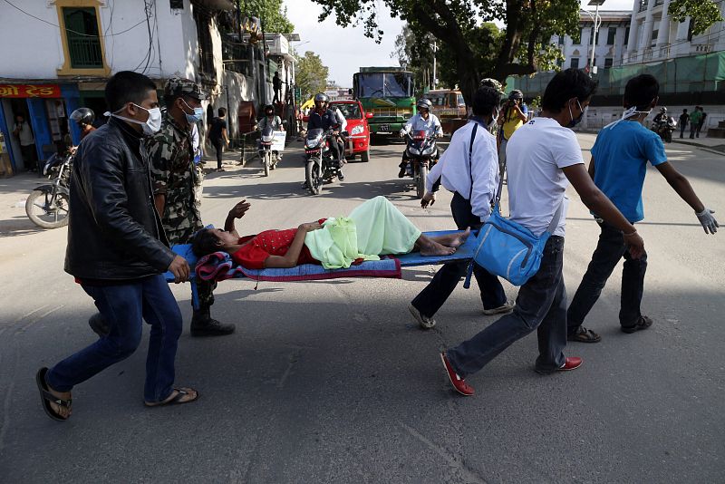 Soldados portan a un paciente de vuelta al hospital tras una evacuación durante el terremoto