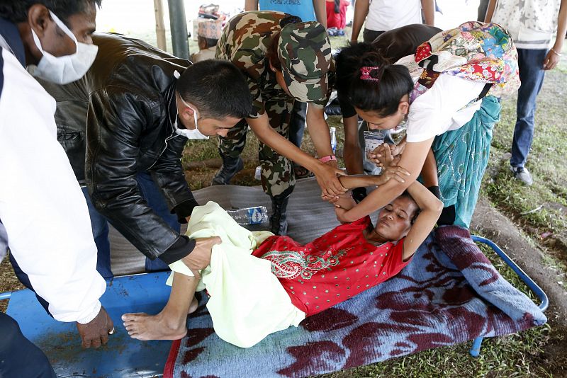 Soldados portan a un paciente de vuelta al hospital tras una evacuación durante el terremoto