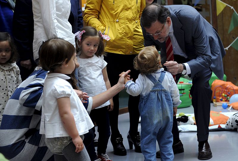 Spain's PM Rajoy greets children during a visit to a toy library in the electoral campaign rally for the Spanish regional and municipal elections in Oviedo