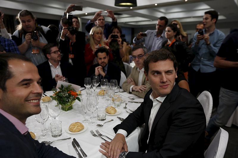 Ciudadanos' party leader Albert Rivera (R) winks as he poses next to Ciudadanos Madrid's regional candidate Ignacio Aguado (L) at the start of a closing campaign dinner at a hotel in Madrid