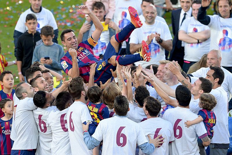 Xavi es manteado por sus compañeros en el Camp Nou.