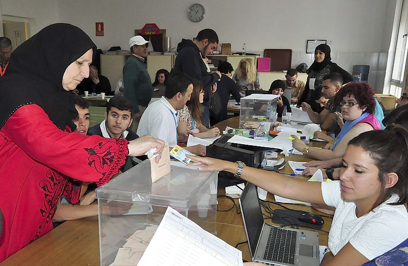 Una ciudadana ceutí deposita su voto en la urna de un colegio electoral de Ceuta.