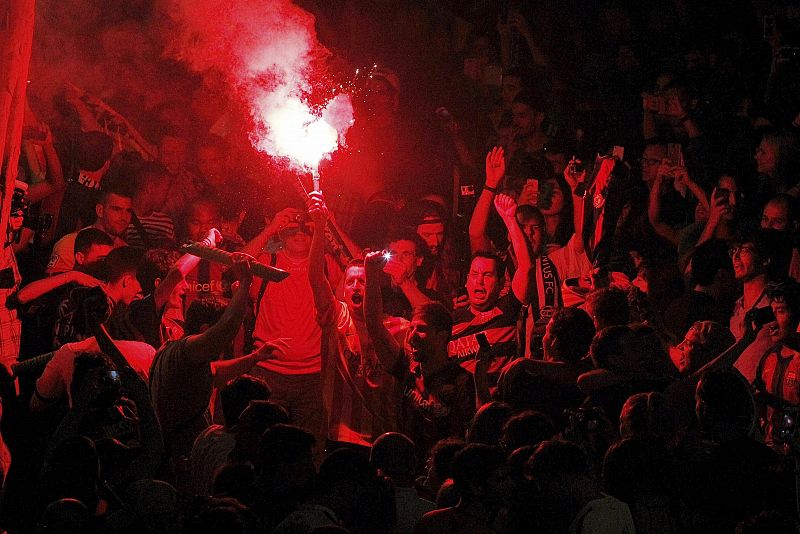 Varios aficionados del equipo azulgrana celebran con bengalas la victoria de su equipo.