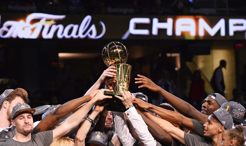 Los jugadores de Warriors sostienen el trofeo de campeones de la NBA.