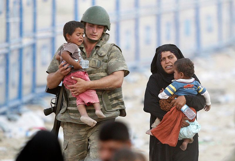 Una familia de refugiados sirios cruza a la provincia turca de Sanliurfa.