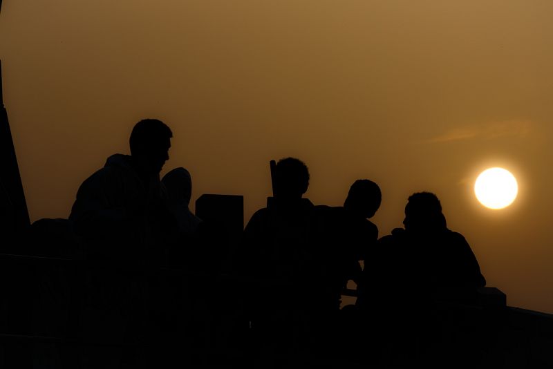 Perfiles humanos mientras cae el sol en la isla.