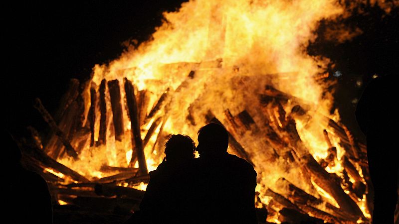 Una pareja ante el fuego en la playa, en Gijón.