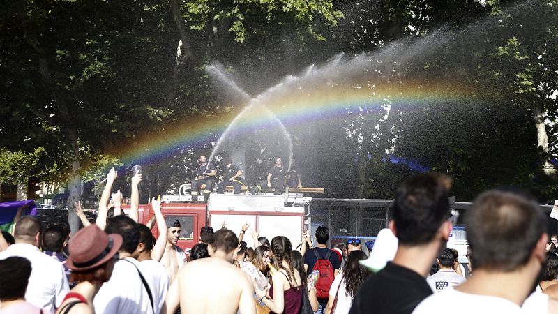 Bomberos de Madrid refrescan a los participantes del tradicional desfile del Orgullo Gay durante el recorrido por las calles de Madrid con el lema "Leyes por la igualdad real ¡Ya!"