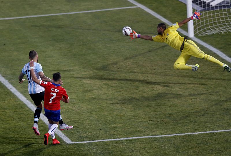 El portero del combinado albiceleste, Sergio Romero, se lanza para detener un disparo de Alexis Sánchez.