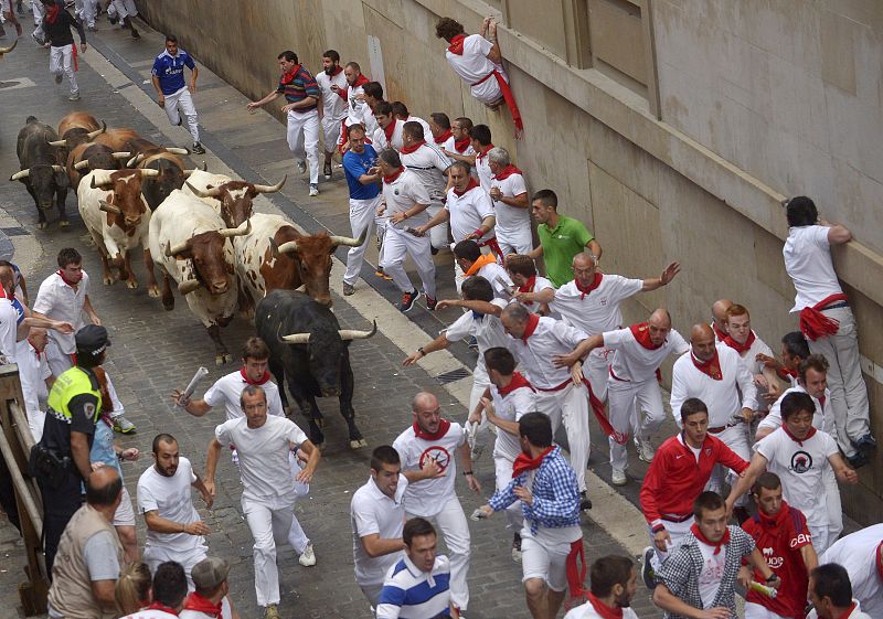 Los corredores tiran de los toros en la cuesta de Santo Domingo