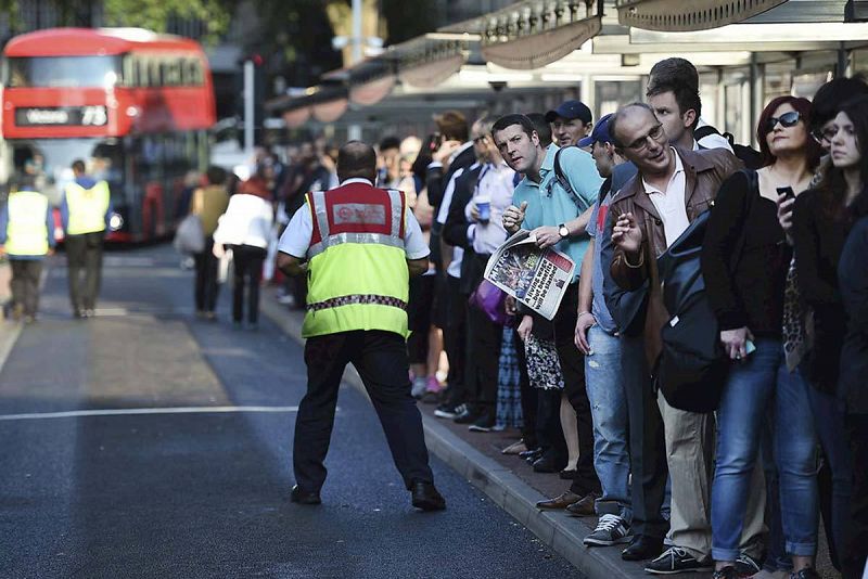 Decenas de londinenses guardan largas colas para tomar un autobús en la estación Victoria en el centro de Londres