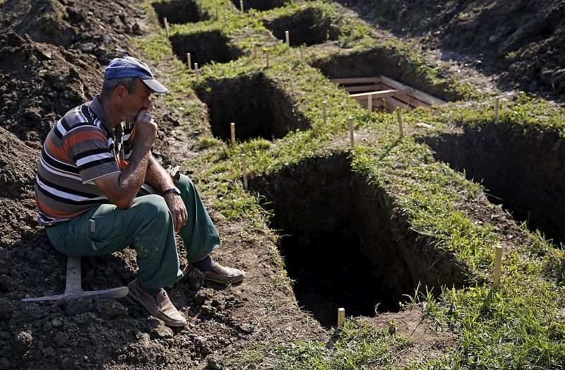 Un trabajador bosnio descansa después de cavar tumbas en el cementerio de Potocari.