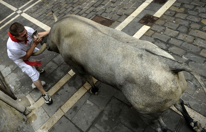 Un mozo se escabulle de los cuernos de un toro en el quinto encierro