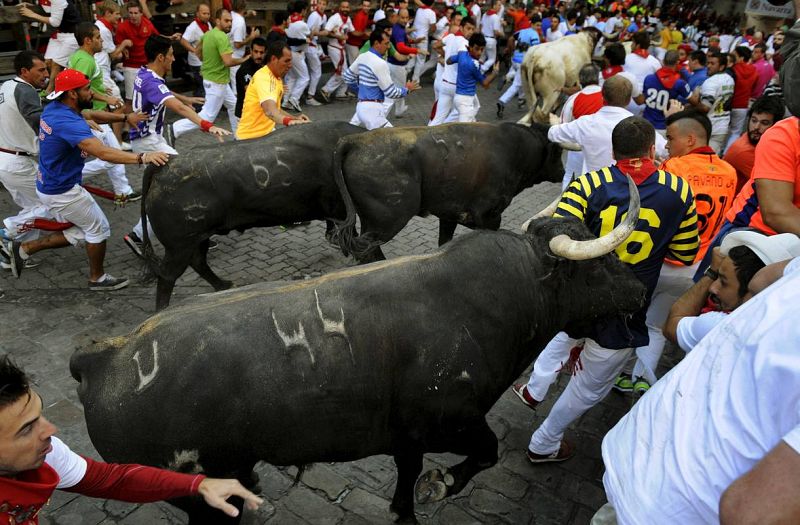 Un corredor arrinconado contra las tablas en el callejón de acceso al coso pamplonés.