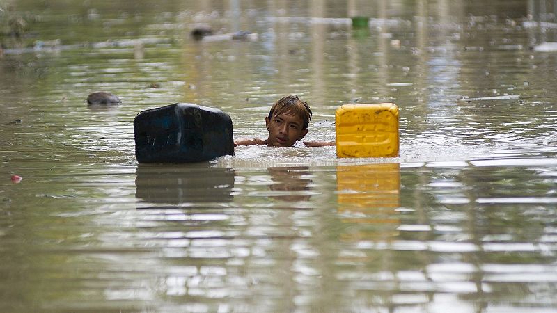 Un hombre nada en una calle inundada de Kalay