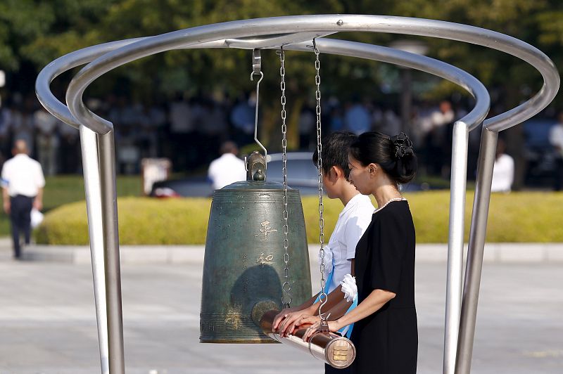 Dos mujeres hacen sonar una campana en el Parque de la Paz de Hiroshima en el mismo momento y cerca del lugar donde hace 70 años se lanzó la primera bomba atómica.